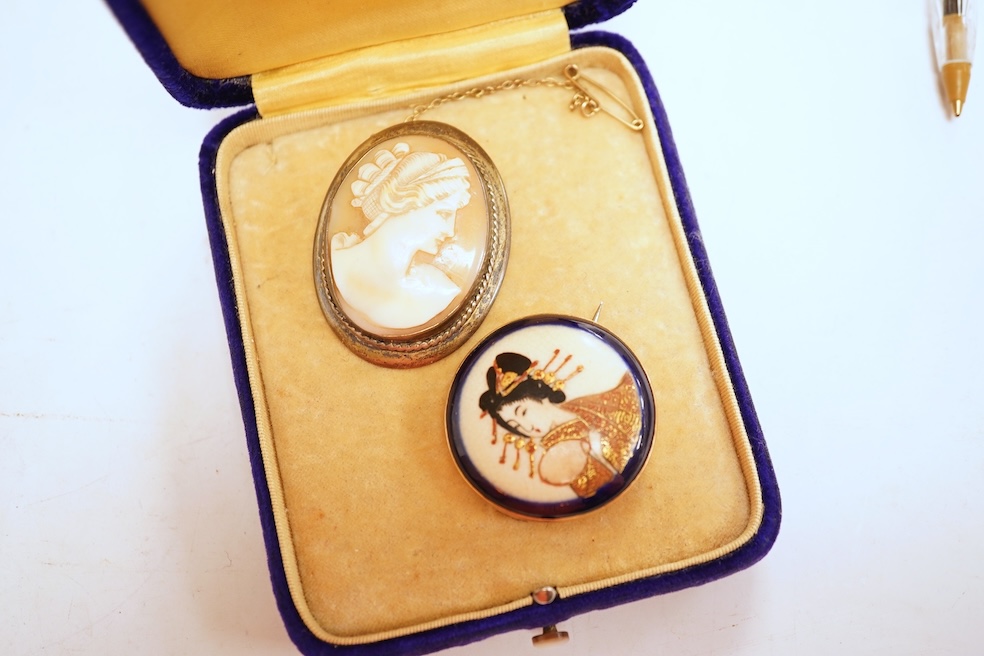 A Satsuma brooch, set with a circular Satsuma plaque depicting an oiran with gilded hair ornaments, mounted in 9ct gold, 3.3cm diameter, British hallmarks; together with an oval shell cameo brooch depicting a classical w